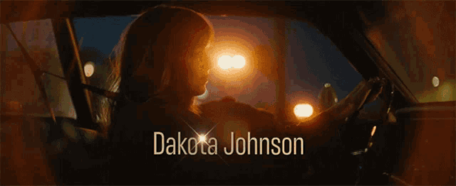 a woman in a car with the name dakota johnson