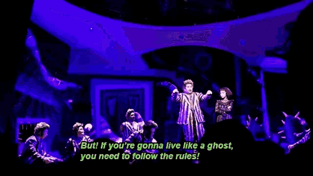 a group of people are standing on a stage in front of a purple background .