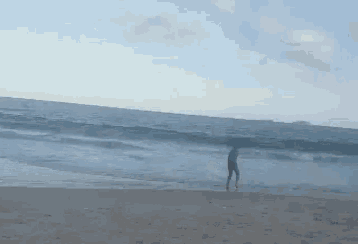 a person walking on the beach near the ocean