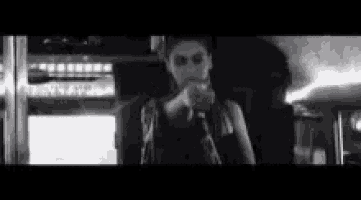 a black and white photo of a woman holding a microphone .