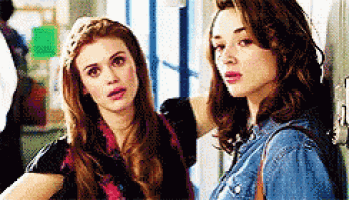 two young women are standing next to each other in a locker room .