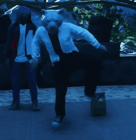 a man in a bear costume is dancing in front of a bag