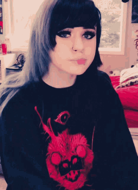 a girl is wearing a black shirt with a red skull and the letter b on it
