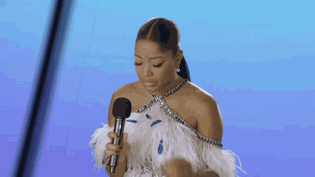 a woman in a white dress holds a microphone