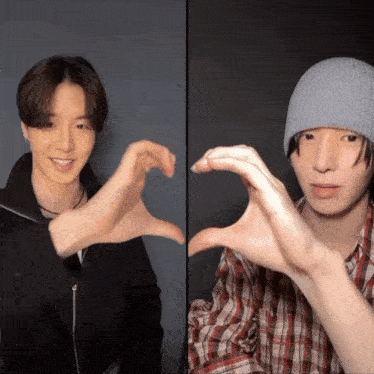 two young men make a heart shape with their hands