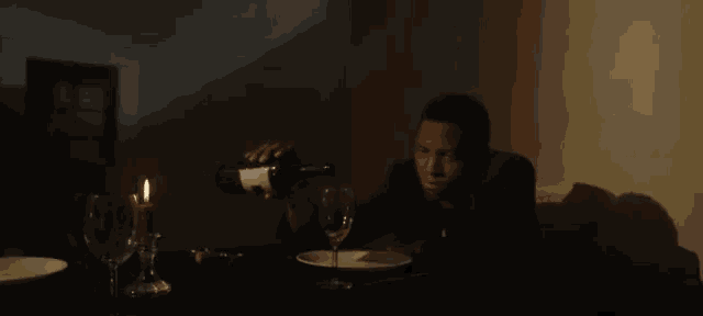 a man pouring a bottle of wine into a wine glass