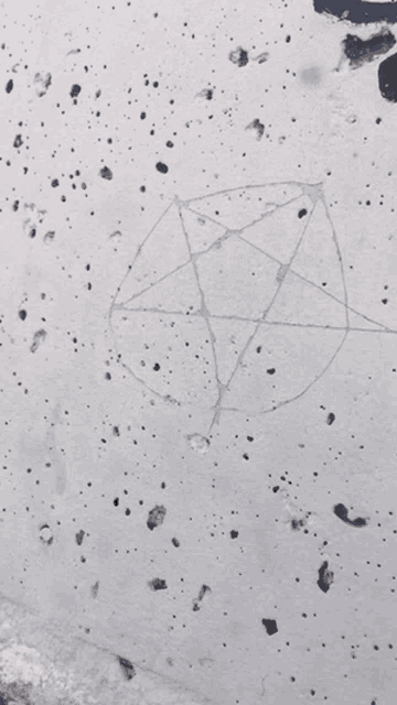 a drawing of a pentagram on a gray surface