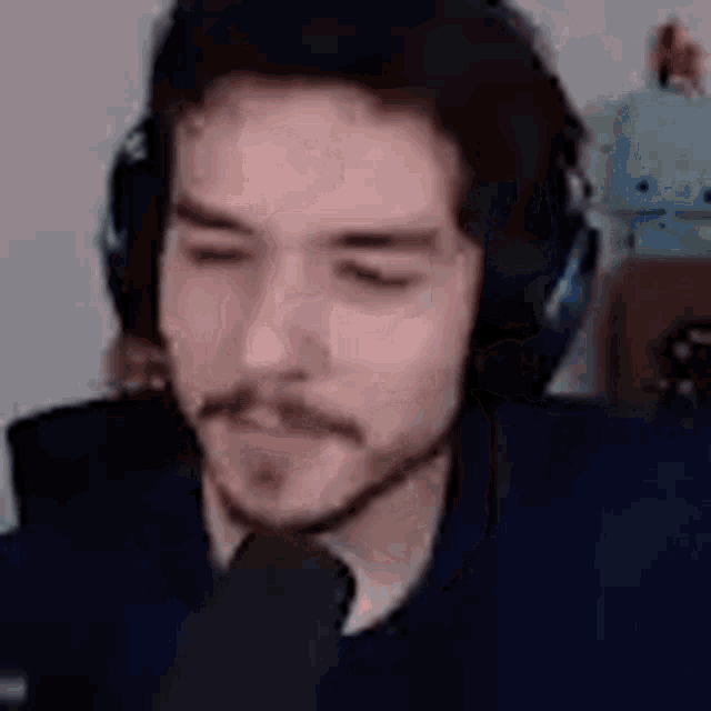 a man with a mustache wearing headphones and a microphone .