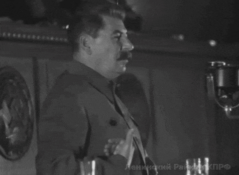 a man with a mustache is giving a speech in front of a microphone with the letters leningrad on the bottom left