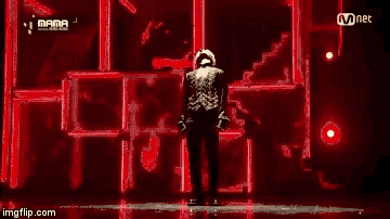 a man stands on a stage in front of a screen that says mama