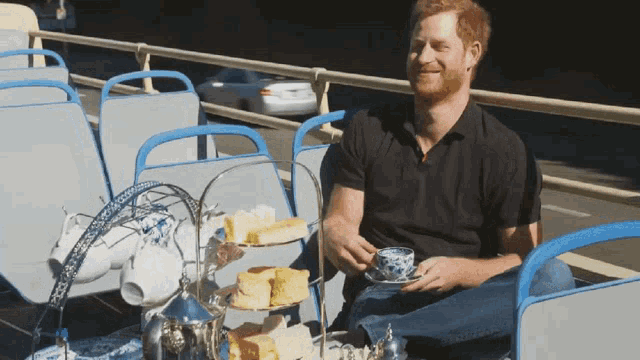 a man sits on a bus with a cup of tea