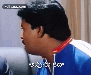 a man in a blue shirt is making a funny face and talking in a foreign language .