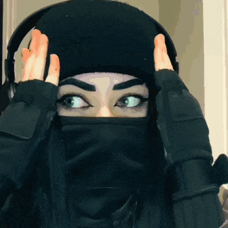 a woman wearing a black beanie and a black mask