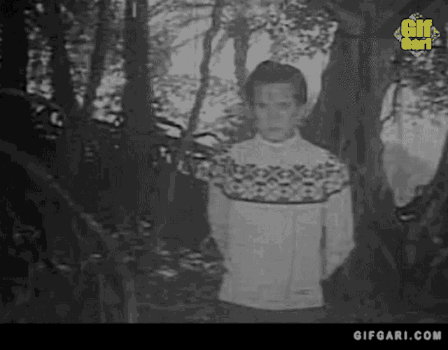 a black and white photo of a person in a forest with a gifgari.com logo on the bottom right