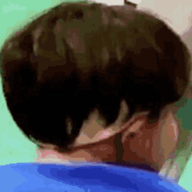 a close up of a person 's back with a blue shirt on