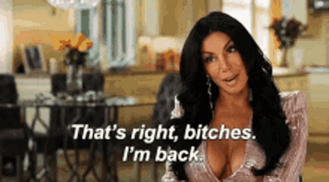 a woman is sitting in a living room and saying `` that 's right , bitches . i 'm back ''