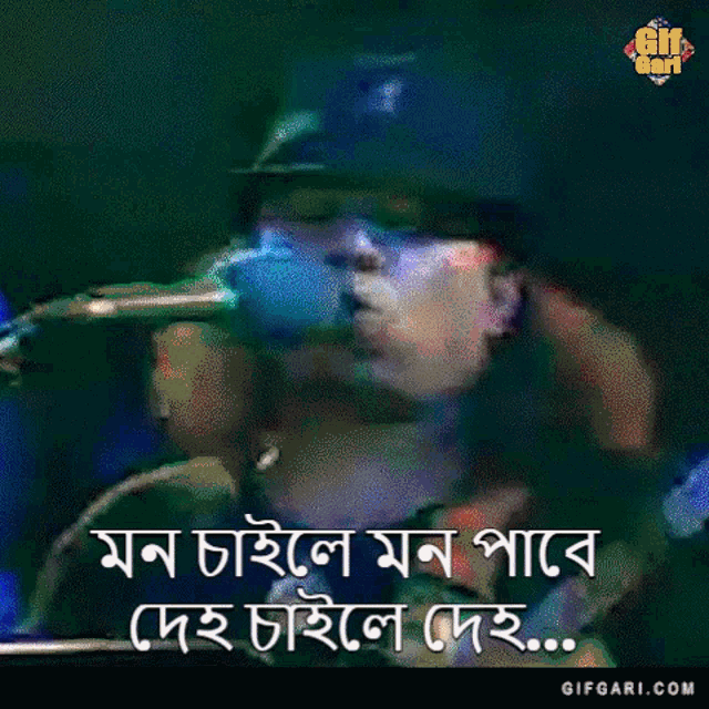 a man in a baseball cap is singing into a microphone while holding a guitar .