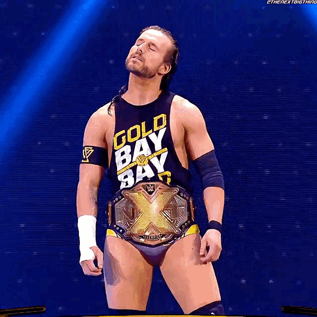a wrestler wearing a gold bay bay shirt