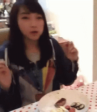 a woman is sitting at a table with a plate of food