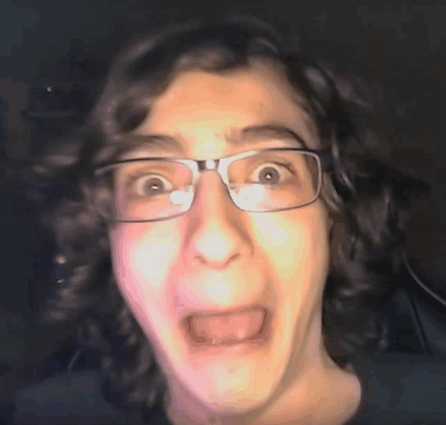 a close up of a person wearing glasses making a face