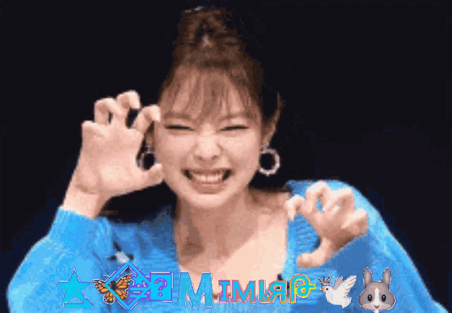 a woman in a blue sweater is making a funny face with the word mimi on the top
