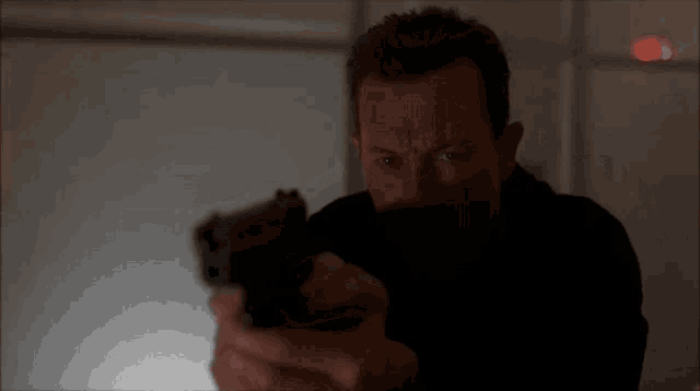 a man in a black shirt is pointing a gun