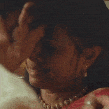 a close up of a woman touching a man 's face with her hand .