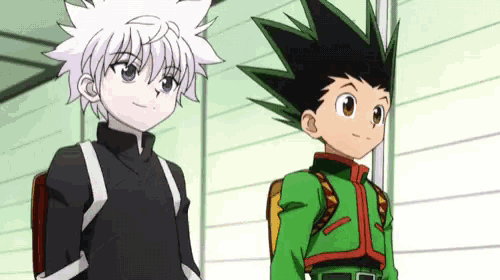 two anime characters , gon and killua , are standing next to each other in a room .