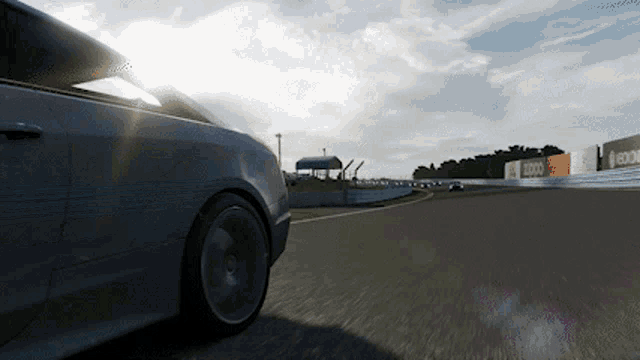a car is driving down a race track with a sign that says edge in the background