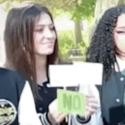 a woman is holding a sign that says `` no '' in her hands .