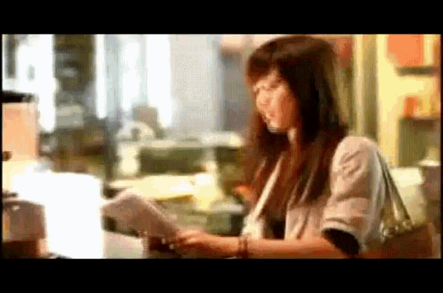 a woman is looking at a piece of paper in a room .