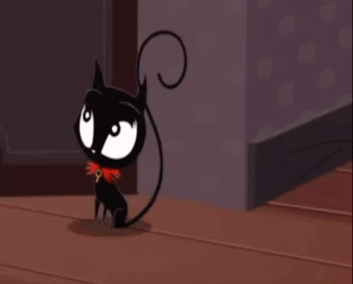 a black cat with a key around its neck is playing with a yellow ball