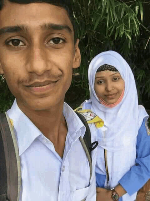 a boy and a girl are posing for a picture