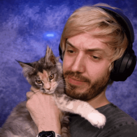 a man wearing headphones holds a cat in front of his face