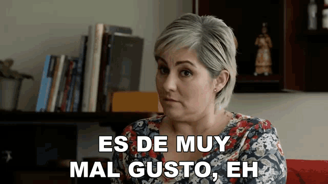 a woman sitting on a couch with the words es de muy mal gusto eh above her