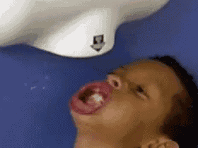 a child is drinking water from a hand dryer