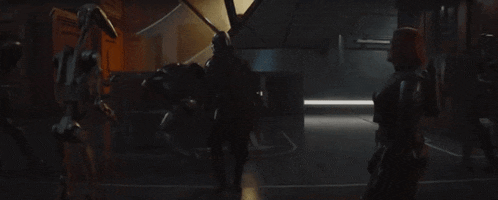 a group of people are standing next to each other in a dark room in a movie .