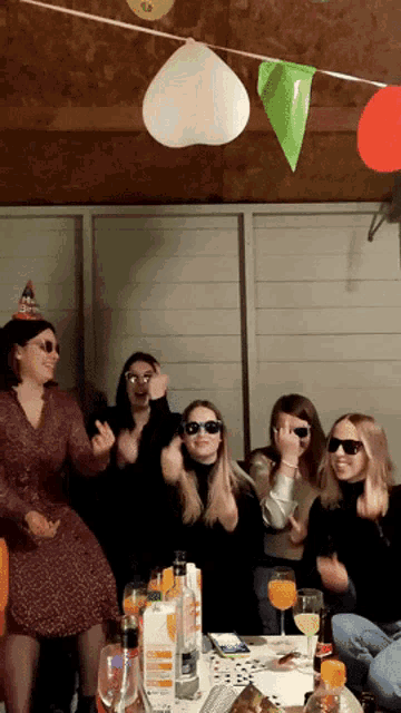 a group of women wearing sunglasses and a party hat