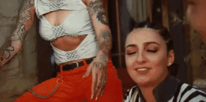 two women with tattoos are standing next to each other .