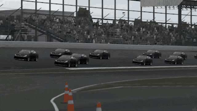 three black cars are racing on a race track