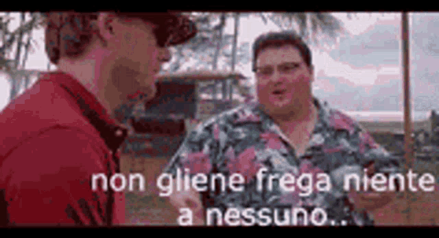 two men are standing next to each other and talking in a foreign language .