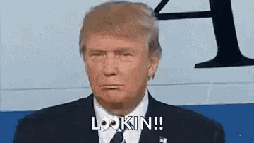 donald trump is wearing a suit and tie and making a face .
