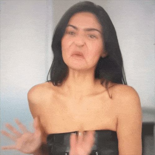 a woman making a funny face while wearing a black strapless top