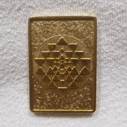 a gold colored item with a triangle pattern on it