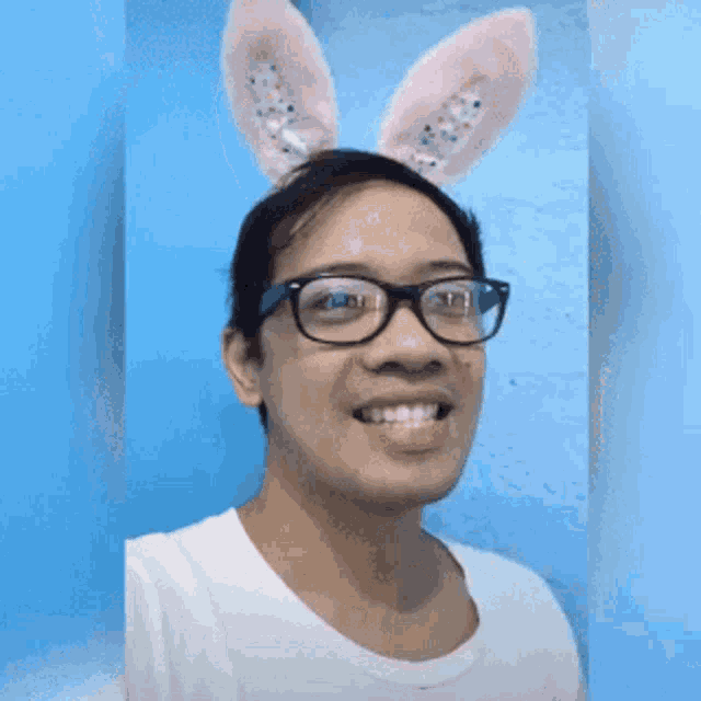a man wearing bunny ears and glasses is making a funny face