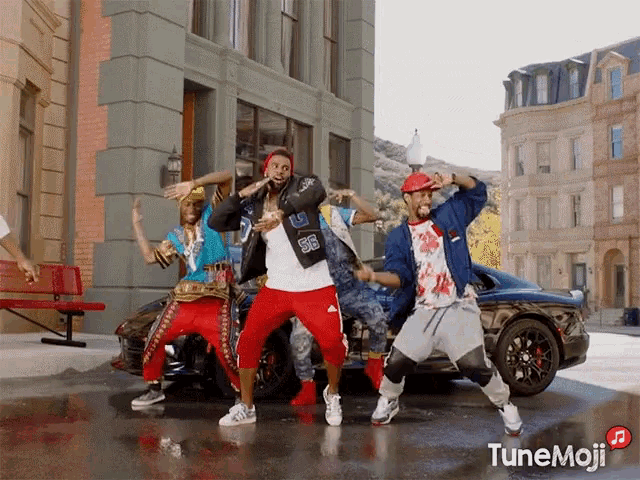 a group of young men are dancing in front of a car with tunemoji written on the bottom