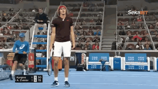 a tennis player stands on the court with a racket in his hand