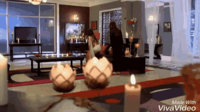 a woman is sitting in a chair in a living room with candles