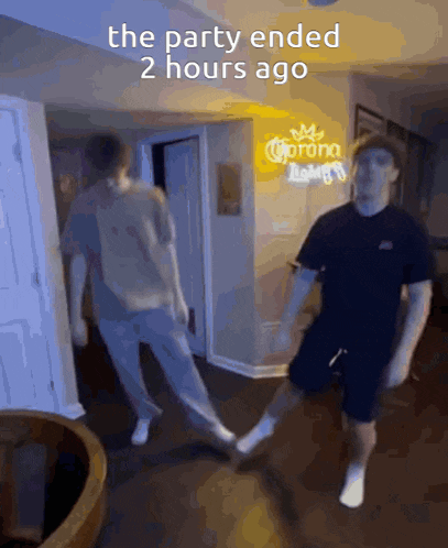two men are dancing in front of a sign that says corona