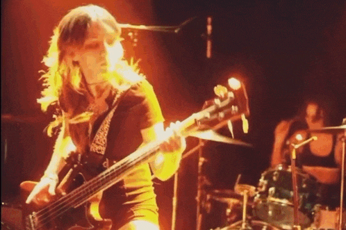 a woman is playing a bass guitar in a band